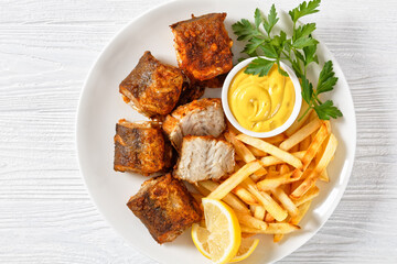 fried pieces of hake on a plate with french fries