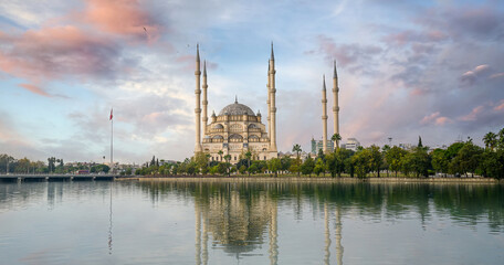 Fototapeta premium Sabanci Central Mosque in Adana, Turkey on Seyhan River. Mosque has reflections in sunny day with blue sky