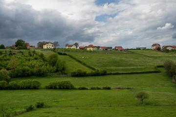 The natural landscape, the beauty and majesty of green meadows and forests. Top view. Rural house in field. Beautiful landscape photography of nature