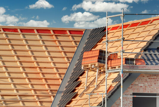 Bauarbeiten / Dachdeckerarbeiten am einger&uuml;steten Neubau / Rohbau auf der Baustelle mit ungedecktem Dach