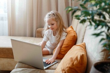 Preschooler girl kid use laptop for remote learning in kindergarten school. Smart calm attentive...