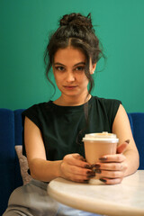 Girl in a cafe drinks coffee