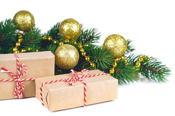 Fototapeta na wymiar Decorated fir branch with golden balls and garland, two gift boxes covered in craft paper isolated on white background