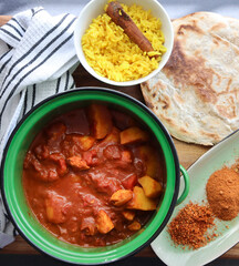 Mild indian chicken curry with yellow rice and a roti