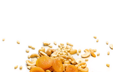White background with dried apricots, cashews and pine nuts at the bottom edge. Healthy food concept. Copy space