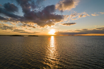 Sunset over the lake. Blue sky and orange sun during summer sundown. 