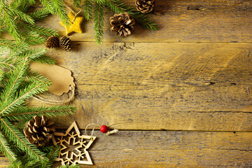 Vintage christmas background - old planked wood board with pine tree branch, pinecones and wooden, golden star