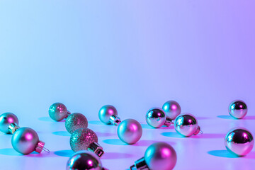 Christmas balls pattern neon background. Xmas bauble on abstract holiday winter gradient backdrop. Happy new year copy space.