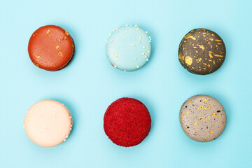 Six multicolored macaroons on a blue background