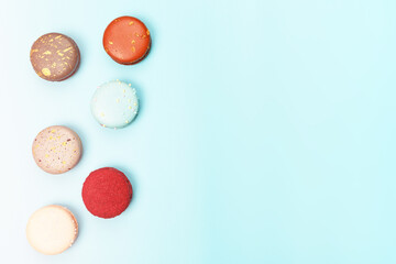 Six multicolored macaroons on a blue background