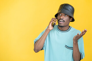 Important news. Puzzled man. Mobile communication. Confused hipster guy feeling doubts talking smartphone isolated yellow copy space.