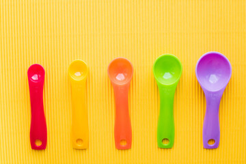measuring spoons on yellow background 