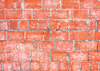 The wall is made of old red brick. Brickwork. Rows of red bricks are held together with gray...