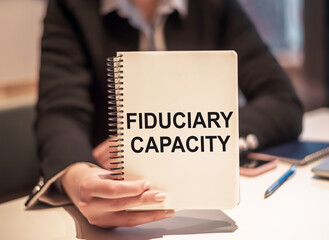 Fiduciary Capacity text is written in the notebook and shown by a businesswoman