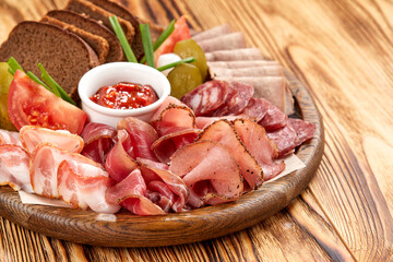Meat platter with selection on wooden background