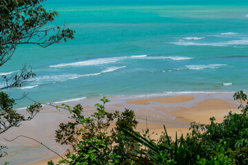 Linda vista de cima de praia com muitas pedras e um céu azul