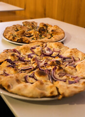 Pizza italiana alla cipolla e pizza al rosmarino. Pizza al ristorante.