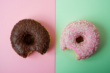Bitten Dessert on a colored background. Dessert colorful snack. Delicious donut with sprinkles....