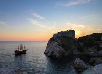 Masted pirate galleon ship sailing the Dubrovnik harbor at sunset