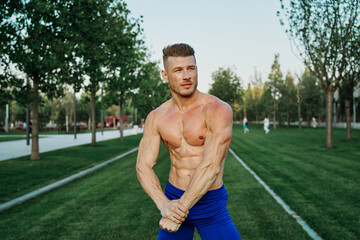 sports muscular man in the park healthy food fitness