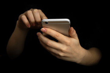 Person uses mobile phone with index finger. Hand with modern smartphone on a black background, communication and techonology concept photo