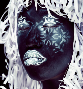 creative makeup like Ethiopian mask, white pattern on black face close up, halloween horror, fashion style print