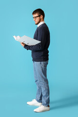 Young man with folder on color background