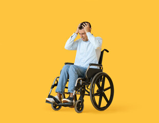 Obraz na płótnie Canvas Depressed young man in wheelchair on color background