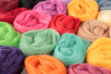 Balls of coiled natural wool for yarn, sewing, felting and making handmade crafts, close-up