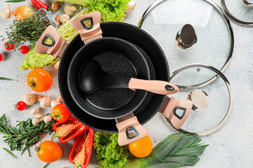 Cooking pots and ingredients for delicious soup on table