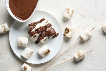 Plate of tasty grilled marshmallows with chocolate on light background