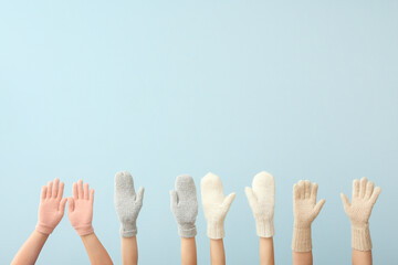 Women in warm gloves on blue background. Winter concept