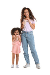 Little African-American girl and her mother with glasses of sweet cocoa on white background