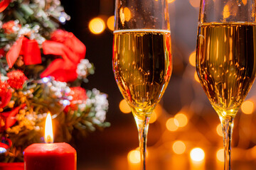 Glasses of champagne on the background of the Christmas tree and burning sparklers. The celebration of Christmas and New Year. Christmas illumination and decoration