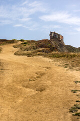Pathway up to a  vandalized and weathered bunker on a hill by the ocean