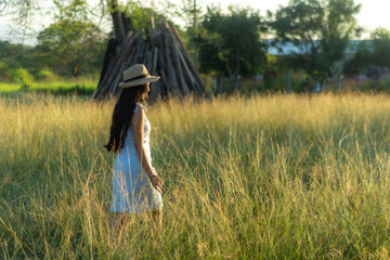 "Black hair brunette woman standing in the field outdoors. Caucasian brunette teen in white dress walking in the countryside
