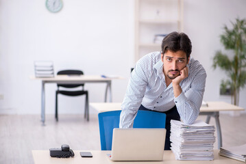 Young male employee and too much work in the office