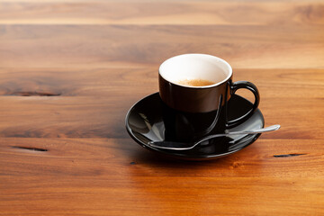 espresso cup of coffee with spoon on wooden table