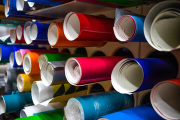 Round rolls of self-adhesive film in the production of interior advertising. Stand for the...