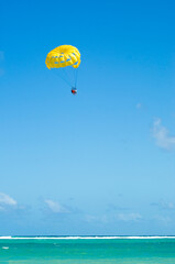 Yellow parasailing  with 3 people towed at beach in Punta Cana