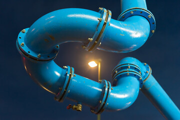 Blue water pipe in a bend with street lamp 