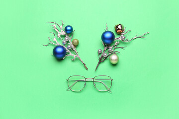 Creative composition with reindeer face made of Christmas decor and eyeglasses on color background
