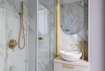 Elegenat and luxurious interior bathroom with shower and bathtub and ceramic sink with golden...