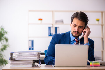Young male employee sitting at workplace