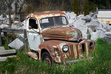 Rusted truck in deep grass and rocks
