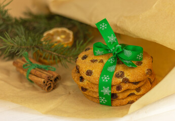 Festive christmas homemade cookies with raisins close-up, cinnamon and lemon wedges on craft wrapping paper