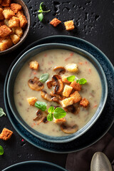 Vegan mushrooms soup with croutons and champignons.
