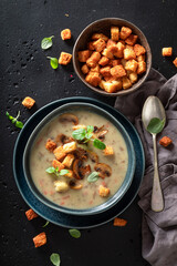 Creamy mushrooms soup with croutons and champignons.