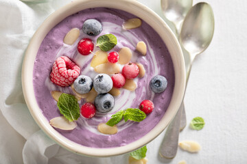 Vegan cream cold soup with frozen berries and mint.