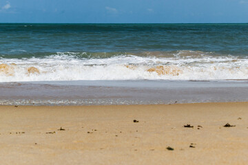 linda praia com areias escuras, ondas e céu azul